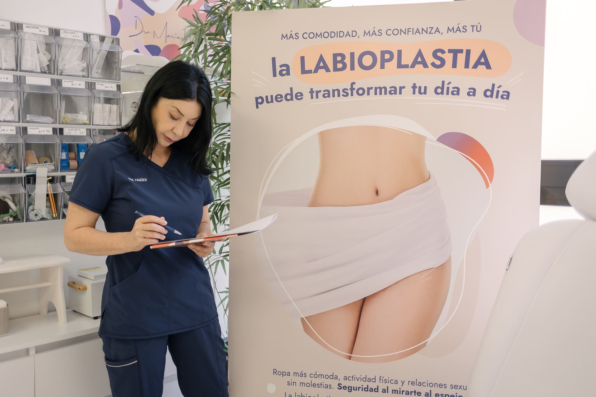 La Dra. Yagües en su consulta junto a información sobre labioplastia